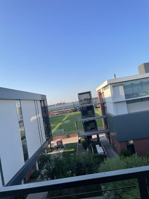 View from a university classroom window over the campus and a sports field