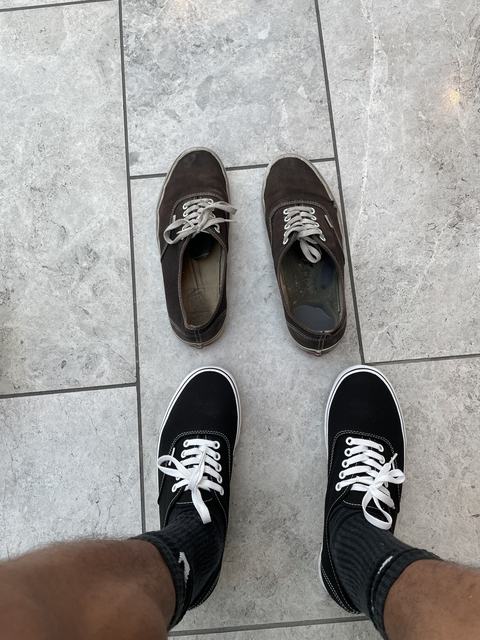 A destroyed pair of sneakers on a mall floor, next to the new pair Phoenix is wearing