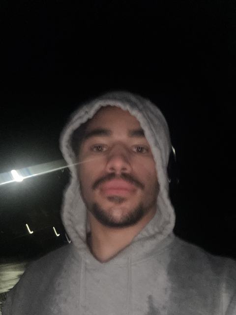 Phoenix in a soaked grey hoodie at night after a long run